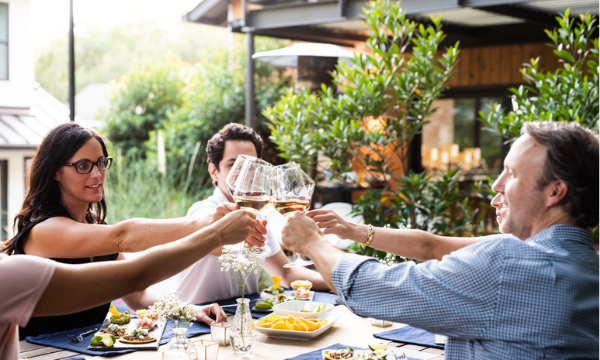 People around a table toasting with wine glasses