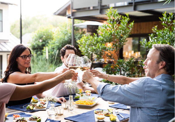 People around a table toasting with wine glasses